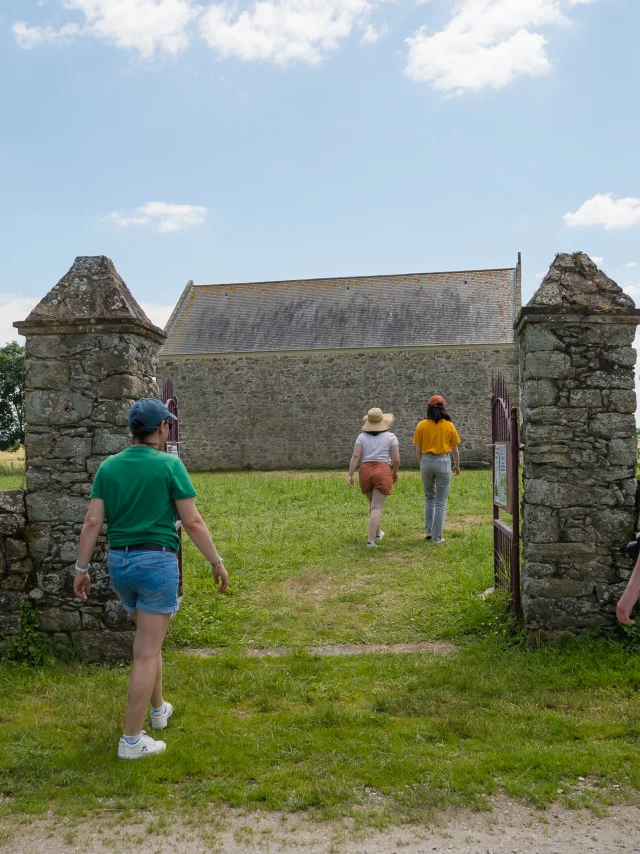 Visiteurs franchissant le portail d'entrée. La Chapelle de Rohars est en arrière-plan.